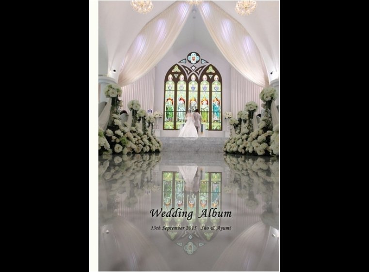 白い大理石のバージンロードに、祭壇のステンドグラスとお二人のシルエットが浮かび上がる表紙が幻想的です。1頁目：結婚式アルバム